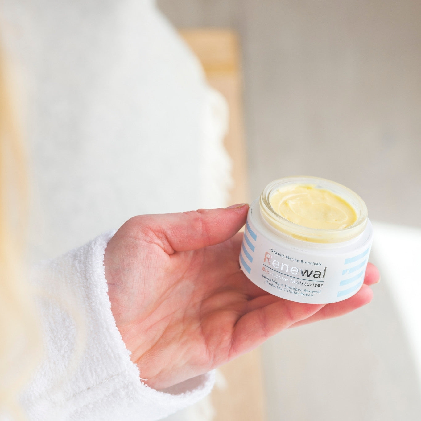Renewal Bio-Active Moisturiser jar with fresh green leaves, highlighting natural hydration and skin rejuvenation benefits.